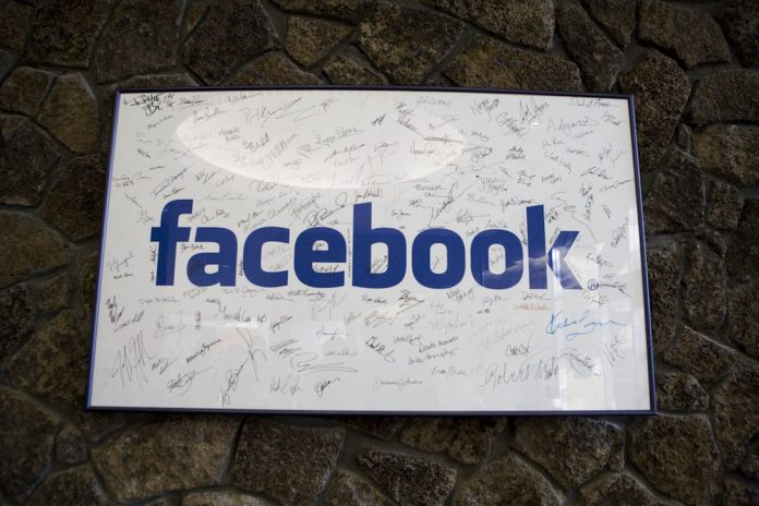 A framed Facebook logo, filled with employees' signatures, hangs in the lobby of the company's Palo Alto, Calif., building in June 2009.