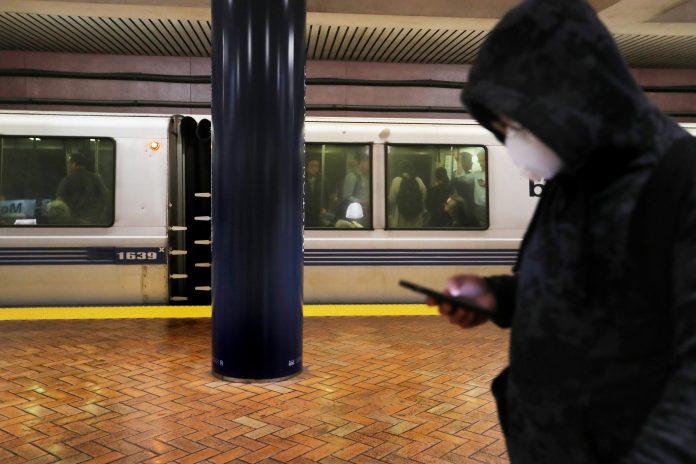 A commuter at a Bay Area Rapid Transit station wears a mask to protect against the coronavirus. 