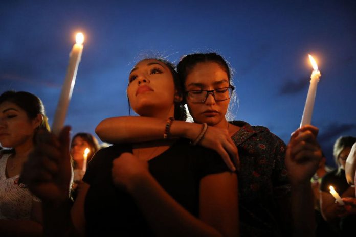 People attend a candlelight vigil at a makeshift memorial honoring victims of the mass shooting in El Paso, Texas.