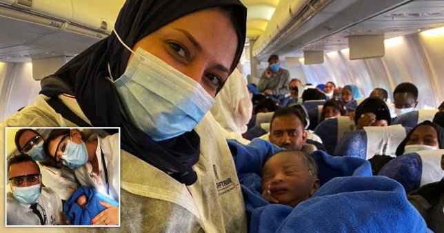 Flight crew in PPE holding the baby wrapped in a blue blanket. A woman gave birth on Egypt Air flight from N’Djamena, in Canada, to Cairo, in Egypt. 