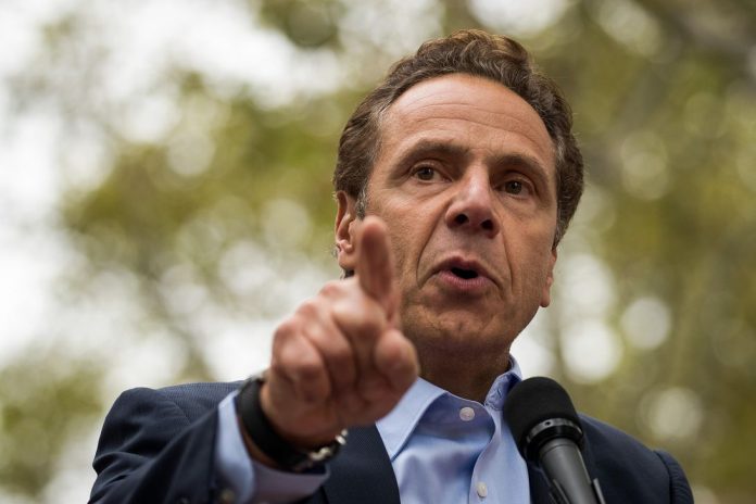 New York Governor Andrew Cuomo speaks at a microphone and points into the crowd during an outdoor union rally in September. On Wednesday, Cuomo enacted net neutrality rules for the state of New York with an executive order.