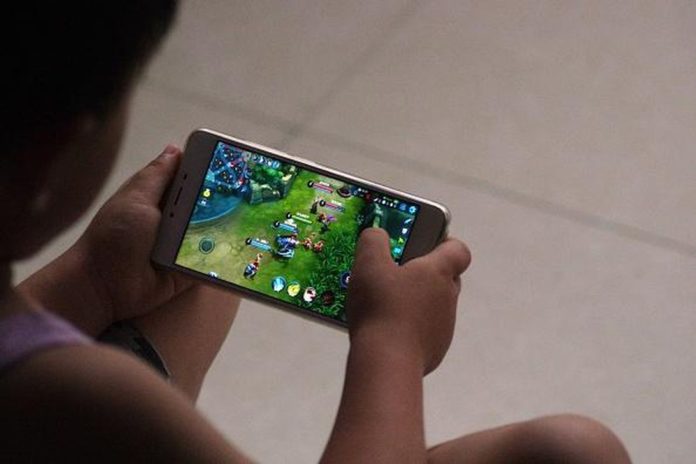 A child plays a game on a smartphone.