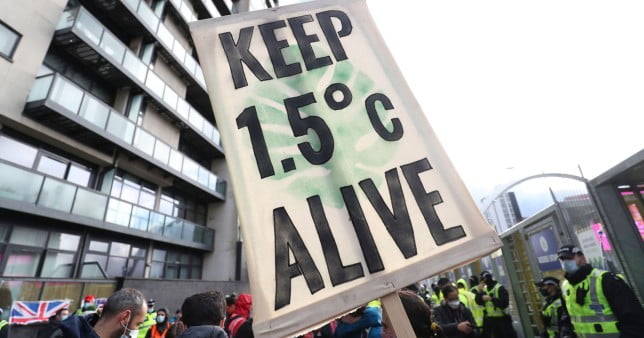 A sign reads keep 1.5°C alive at a climate protest.