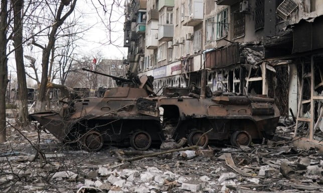 MARIUPOL, UKRAINE - MARCH 26: A wrecked tank is seen near a damaged building as civilians are being evacuated along humanitarian corridors from the Ukrainian city of Mariupol under the control of Russian military and pro-Russian separatists, on March 26, 2022. (Photo by Stringer/Anadolu Agency via Getty Images)