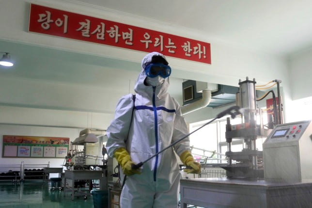 A health official of the Pyongyang Sports Goods Factory disinfects the floor of a work place in Pyongyang, North Korea, Tuesday, June 14, 2022. (AP Photo/Cha Song Ho)