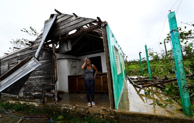 Tobacco company worker Caridad Alvarez stands in her house destroyed by Hurricane Ian