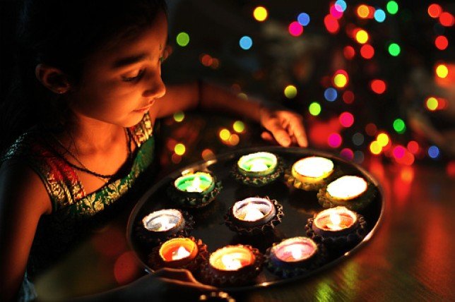 A young girl carrying candles at a Diwali celebration