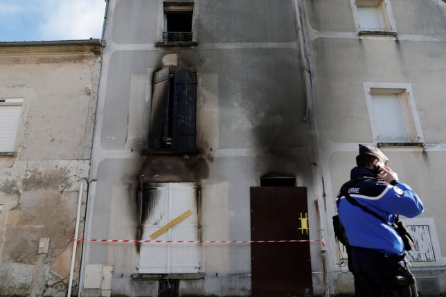 A French gendarme stands in front of the house where a mother and her seven children have died in a fire in Charly-sur-Marne, northern France, February 6, 2023. REUTERS/Pascal Rossignol