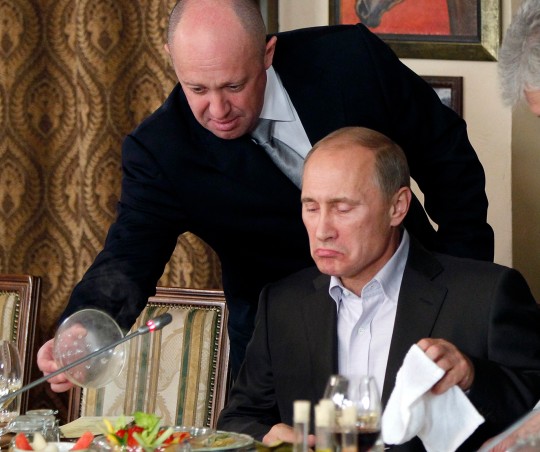 FILE - Yevgeny Prigozhin, top, serves food to then-Russian Prime Minister Vladimir Putin at Prigozhin's restaurant outside Moscow, Russia on Nov. 11, 2011. Prigozhin, the millionaire owner of the Wagner Group private military company, has used his longtime ties with Russian President Vladimir Putin to increase his clout. (AP Photo/Pool, File)